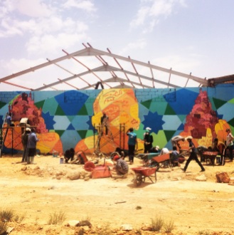 Working on a new piece right outside of the Za'atari Syrian refugee camp with boys who smuggle goods into the camp. There is little legal trade in the camp other than essentials, so these guys risk frequent beatings by the cops to make money on the huge black market. In our mural the kids envision the building of a new sense of community, as the old one has been lost.
