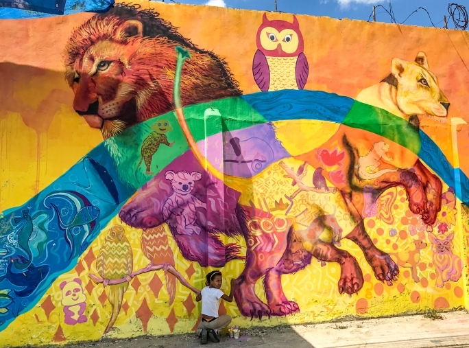 A girl puts her creativity in this animal section of the mural