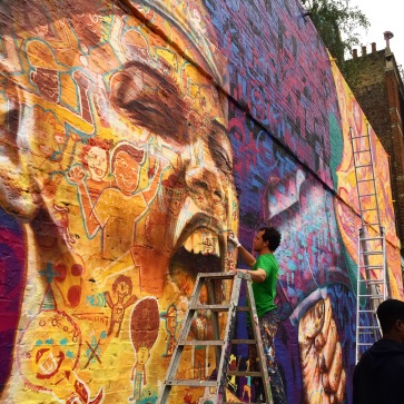 London, UK 2015: Joel at work on one of his trademark portraits that incorporates the characters of many participants.